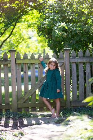 Toddler modeling green corduroy long sleeve dress