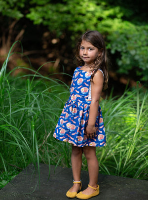 Toddler modeling girls pinafore dress in funky fun blue ramen print